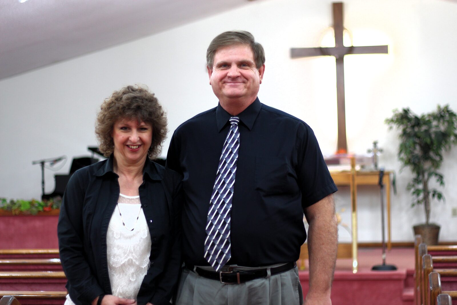 Matt and Brenda Farkas standing together at the front of their church sanctuary.